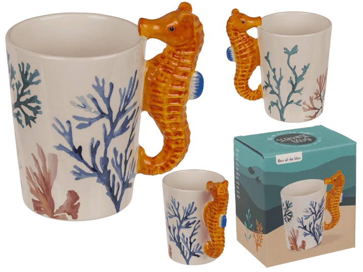 Taza original blanca con corales dibujados y asa en forma de caballito de mar naranja, vista con caja de regalo