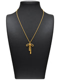 Collar dorado de mujer con colgante de lazo estilizado sobre expositor negro y fondo blanco
