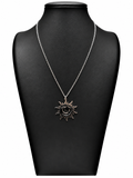 Collar Solana plateado con sol de rayos ondulados, luna creciente y estrella central sobre busto negro