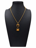 Collar dorado con colgante de reloj de arena y motivos de luna y estrellas sobre expositor negro y fondo blanco