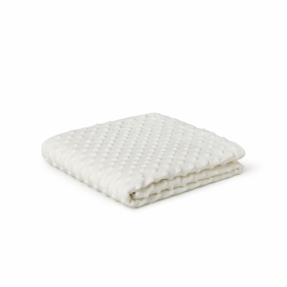 Manta beige crema para bebé doblada con textura de topitos